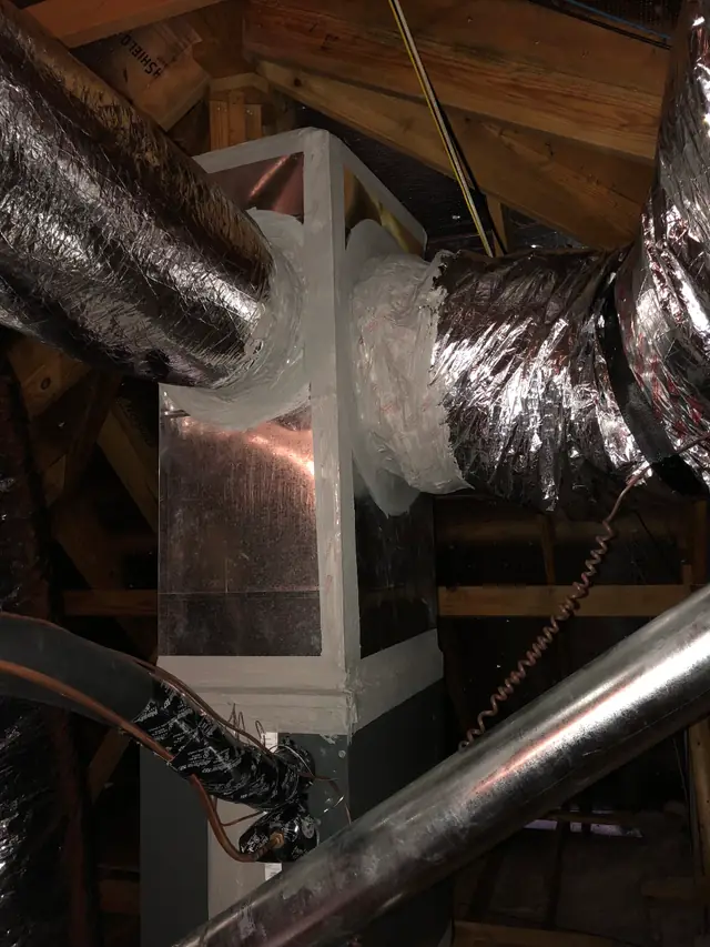 An attic plenum with insulated flex ducts joined at a sheet metal boot